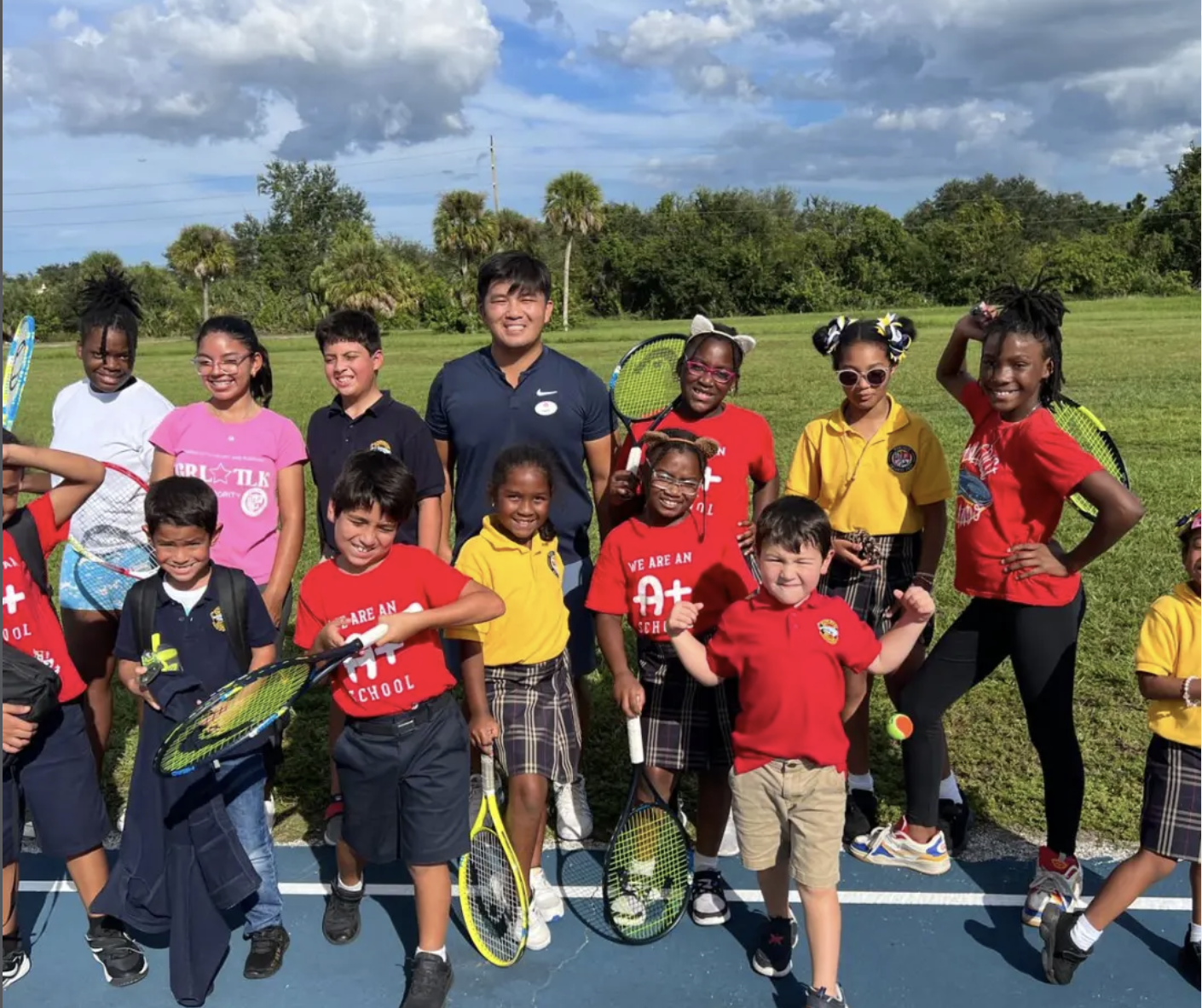 Group of PRTF junior players holding racquets together on the court